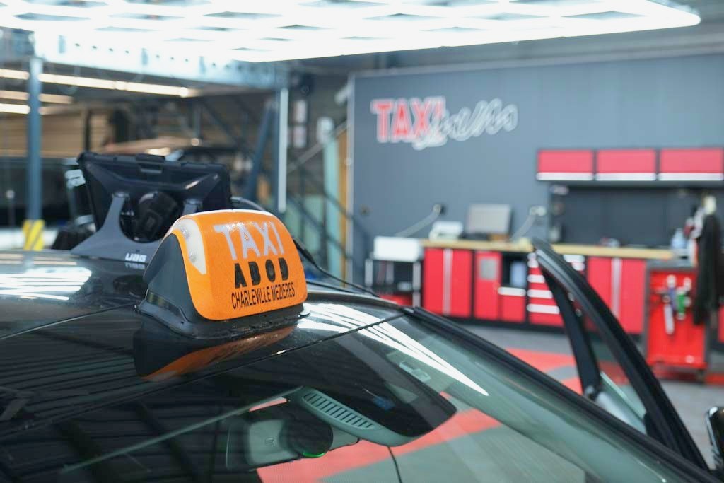Lumineux taxi posé sur le toit d’un véhicule dans l’atelier Taximum, à Reims